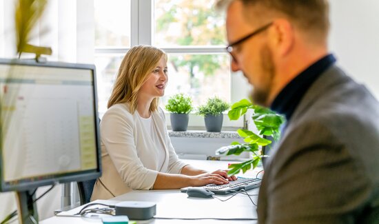 Zwei Personen sitzen im Büro und beschaffen Lizenzen bei Softwarehersteller.